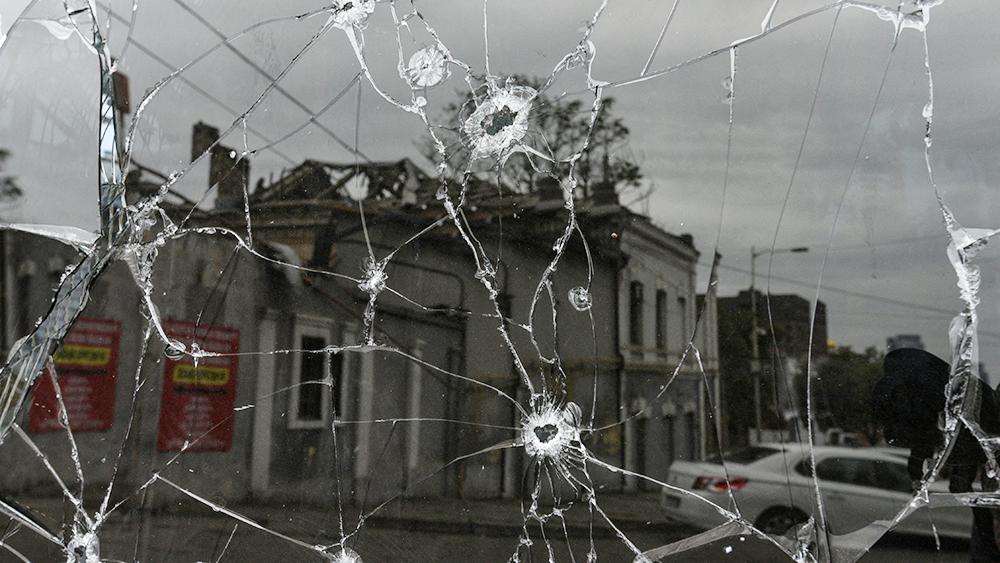A building damaged by a Russian missile strike is reflected in a window broken with shrapnel, amid Russia's attack on Ukraine in central Dnipro, Ukraine September 11, 2022.