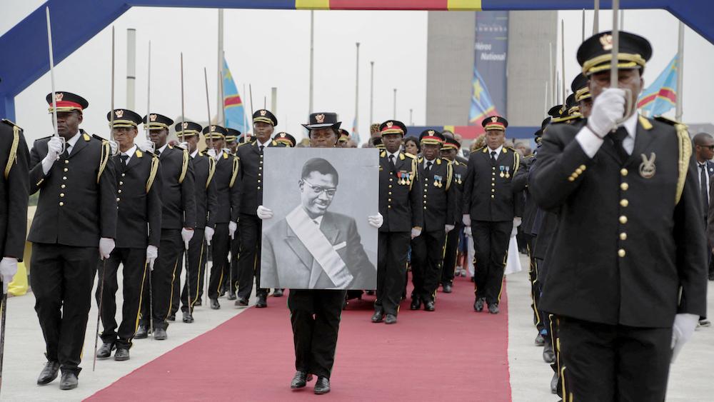 member of the guard of honour carries a poster the murdered Congolese independence hero Patrice Lumumba, during his burial ceremony after his remains were returned to his family by the Belgian government in Kinshasa, Democratic Republic of Congo June 30, 2022.