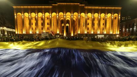 Demonstrators hold a Ukrainian flag during an anti-war rally in front the Parliament building in Tbilisi, Georgia, March 7, 2022.