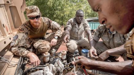 A German army Bundeswehr instructor speaks to Mali soldiers during a car repair training at the EUTM military training mission in Koulikoro, Mali, April 6, 2016